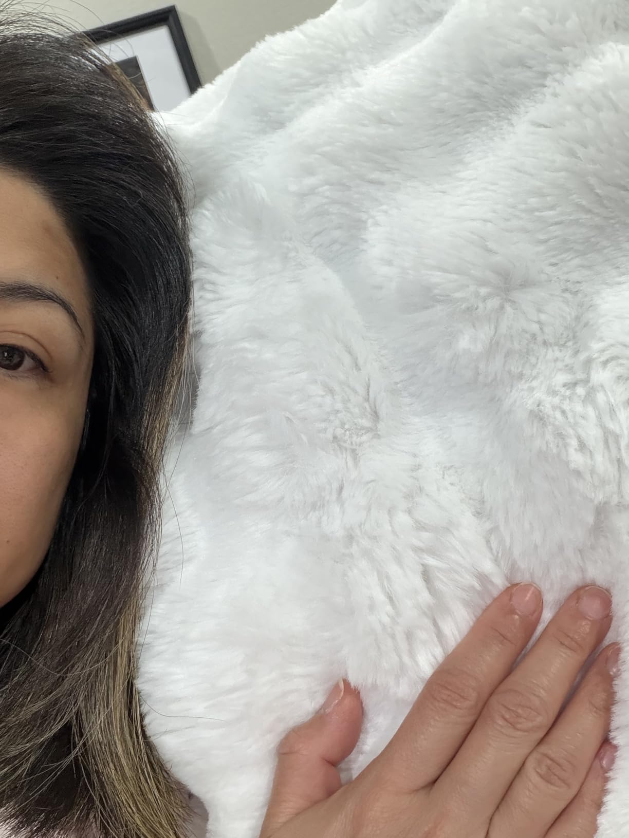 Customer selfie showing the gentle softness of her Aruva SereneWeave throw in bright room lighting