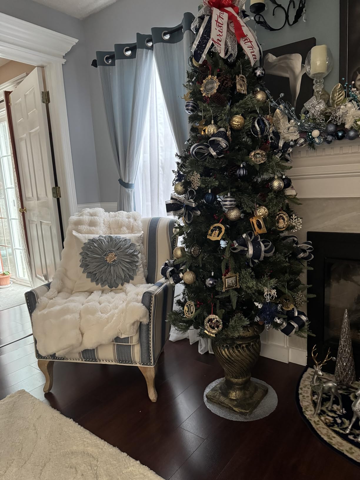 Customer photo showing Aruva SereneWeave throw draped over a living room chair with a fireplace, decorated Christmas tree, and window in the background.